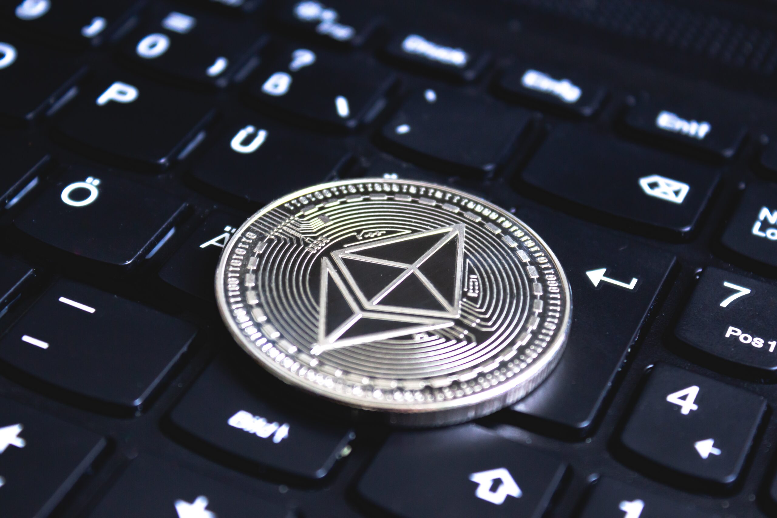 Ethereum coin placed on a black computer keyboard